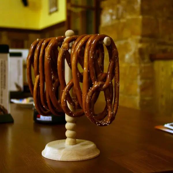 Brezn hängen an einem Holzständer auf einem Tisch